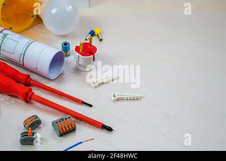 Flat composition with electrician tools on white background. Place for text. Selective focus. Stock Photo