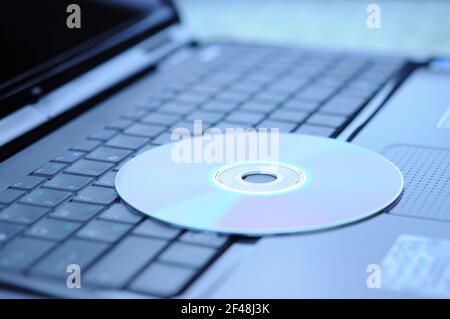 DVD disk lying on a laptop keyboard Stock Photo