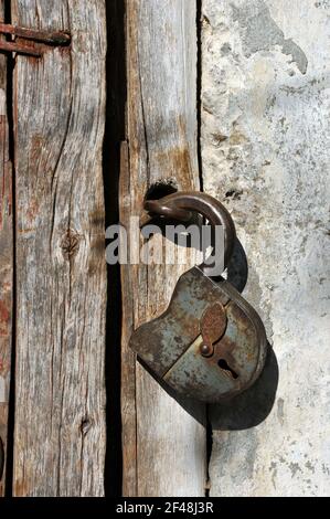 Rusted open padlock on the old wooden door. Stock Photo