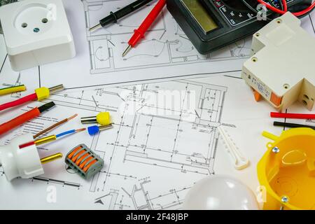 Flat lay composition with electrician's tools on house plan. Space for text.Selective focus. Stock Photo