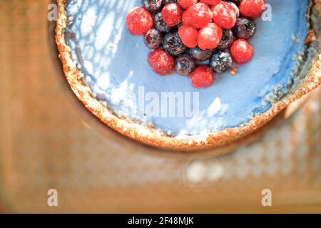 Berry nut cheesecake on a wooden chair with a sunshine, Close-up view from above Stock Photo