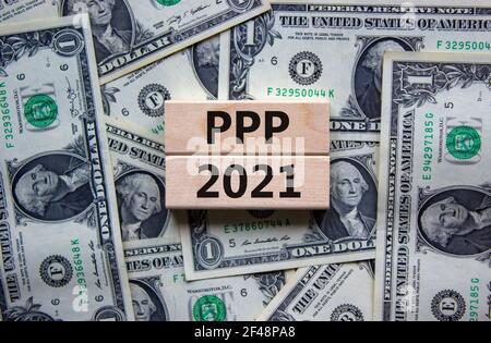 PPP, paycheck protection program 2021 symbol. Concept words PPP, paycheck protection program 2021 on wooden blocks on a beautiful background from doll Stock Photo