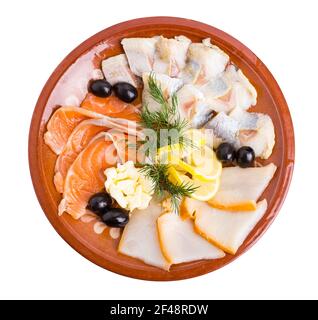Delicious fish platter. Salmon and smoked sturgeon served with lemon and black olives. Isolated on a white background. Stock Photo