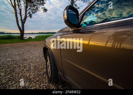 The car is close-up on the shore of a picturesque lake. Stock Photo