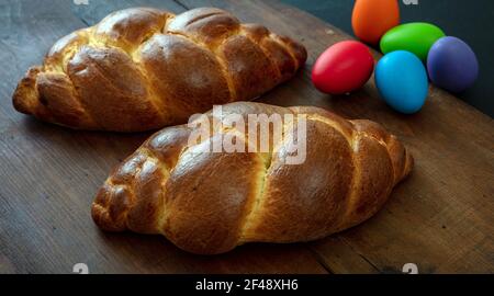 Easter eggs and sweet bread, tsoureki cozonac loaf on wood table background, Festive traditional religion dessert, braided brioche Stock Photo