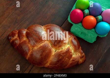 Easter eggs and sweet bread, greek tsoureki cozonac loaf on wood table background, top view, Festive traditional religion dessert, braided brioche, Stock Photo