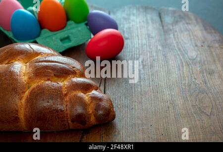 Easter greeting card template. Orthodox easter sweet bread and colorful eggs, tsoureki cozonac loaf on wood table background, Festive traditional reli Stock Photo
