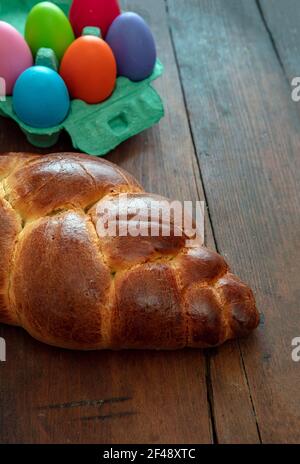 Easter sweet bread and colorful eggs, tsoureki cozonac loaf on wood table background, Festive traditional religion dessert, braided brioche, Stock Photo