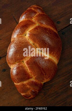 Easter sweet bread, Braided brioche, tsoureki, challah. Loaf on wooden table background, top vertical view. Festive traditional religion dessert Stock Photo