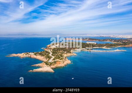 Athens Greece riviera coast, Vouliagmeni, panoramic aerial drone view of the bay and peninsula, south coast. Cloudy blue sky, calm sea water Stock Photo