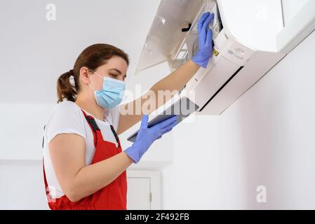 Female technician using digital tablet and repairing air conditioner Stock Photo