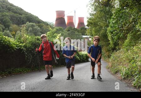 Walking home from school boys walking up steep Hill after a school day. pupils children walk home steep hill Britain Uk. PICTURE BY DAVID BAGNALL Stock Photo