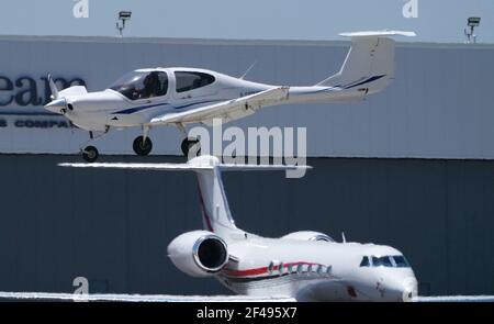 Van Nuys, Ca, USA. 14th May, 2017. A small single engine plane that is on its landing approach appears to be parked stationary on top of the tail of a parked private jet on the west side of the Van Nuys Airport.VNY plays a crucial role in the Southern California airport system, serving a variety of private, corporate and government aviation needs. By providing a place for general aviation, which encompasses all flying other than scheduled air carrier service or the military, VNY enhances both safety and efficiency at the region's commercial airports.As part of the regional approach to meeting Stock Photo