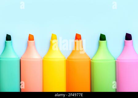 Highlighter colored Markers pens on a blue background Stock Photo