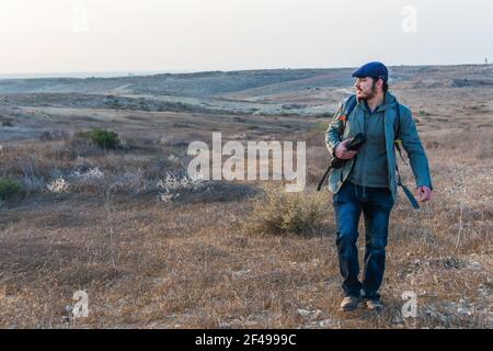 A backpack hike on the desert smiling and enjoying sunset. Travel and active lifestyle concept. Stock Photo