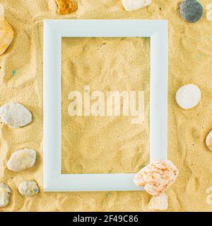Summer beach concept with rocks on sandy background. Summer abstract tropic art with frame. Stock Photo
