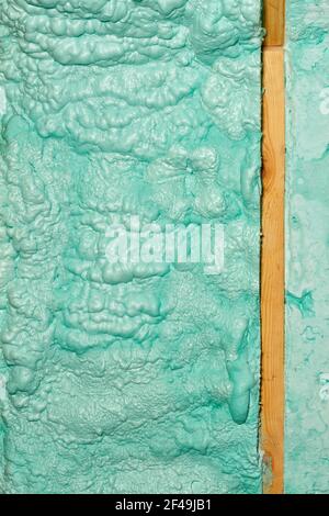 Texture and background of a wall made of ecological construction foam in a light green color near a wooden beam. Stock Photo