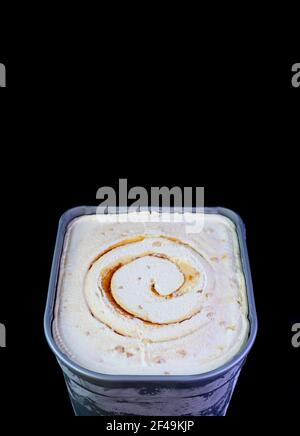 Tub of Delicious Salted Caramel Macadamia Nut Ice Cream Isolated on Black Background Stock Photo