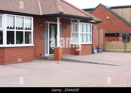 Modern red brick bungalow with block paving drive and block paving wheelchair ramp Stock Photo