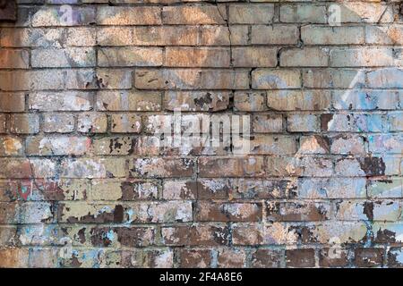 Cracked brick wall background with multiple layers of paint, horizontal aspect Stock Photo