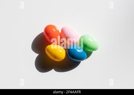 Top view of five colorful plastic Easter eggs in the sun isolated on a white background. Stock Photo