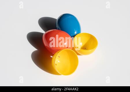 Three colorful plastic Easter eggs in the sun isolated on a white background. Stock Photo
