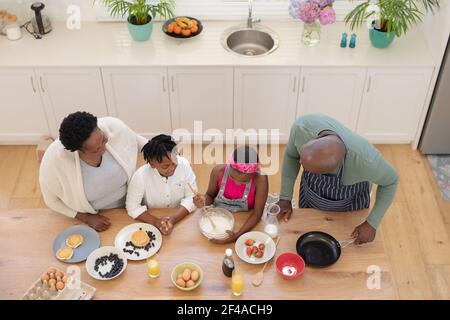High angle view of african american grandparents teaching grandchildren cooking in the kitchen Stock Photo