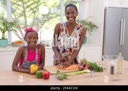 Portrait of happy african american mother teaching daughter cooking in the kitchen Stock Photo