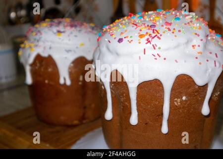 Easter holidays sweet bread, paska composition decorated with sweet sugar icing. Orthodox handmade kulich with topping. Spring holidays food on kitche Stock Photo