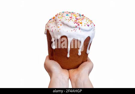 Hands holding easter traditional sweet bread, paska decorated with sugar icing isolated on white background. Orthodox delicious home handmade kulich w Stock Photo