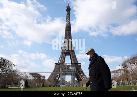 Paris, France. 19th Mar, 2021. A man wearing a face mask walks in the Champ de Mars in Paris, France, on March 19, 2021. French Prime Minister Jean Castex on Thursday announced 'new massive measures' to curb COVID-19 in the country's 16 worst-hit regions, including Paris. Starting Friday midnight, about 18 million French people in regions such as Paris, Hauts-de-France in the north as well as the Alpes-Maritimes on the Mediterranean should stay at home, Castex announced at a press briefing on the epidemic situation. Credit: Gao Jing/Xinhua/Alamy Live News Stock Photo