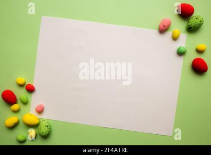 Creative layout made with colorful Easter eggs on green background. Spring holidays concept. Copy space paper card Stock Photo