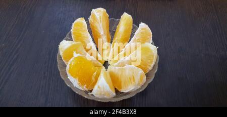 orange slices in a glass cup on a wooden table Stock Photo
