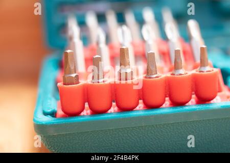 Drill bit kit, close up. 1-inch steel square driver bits in foreground. The kit is blue green with red driver sets. Beautiful defocused and abstract v Stock Photo