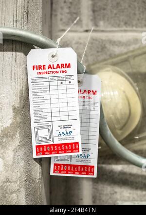 Fire alarm inspection tags with deficiencies. During testing fire protection technicians have marked equipment from the alarm system in need of immedi Stock Photo