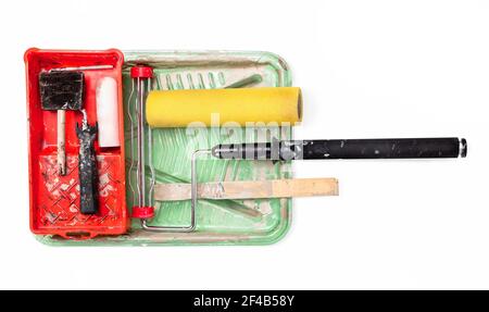 Well used painting tools. Top view of paint trays, foam roller, extension pole, wood stick and cut-in brush.. Concept for DIY home renovation and touc Stock Photo