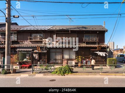 tokyo, japan - march 23 2021: Traditional Showa era Japanese wooden houses rehabilitated into old-Fashioned retro shops in the quiet neighborhood of Y Stock Photo