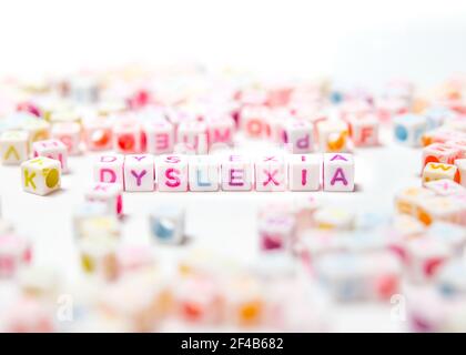 Dyslexia spelled in colorful block letters, perspective view. Selective focus on Dyslexia with blurred and defocused letter in foreground and backgrou Stock Photo