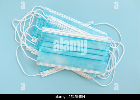 Medical protective mask isolated on blue background. Disposable surgical face mask cover mouth and nose. Stock Photo