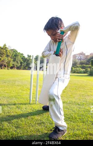 Young boy batting in protective gear during a cricket Stock Photo