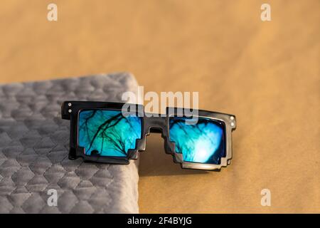 Pixel sunglasses model with blue lenses and black frame closeup in a sunny day. Selective focus Stock Photo