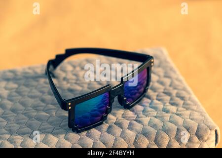 Pixel sunglasses model with blue lenses and black frame closeup in a sunny day. Selective focus Stock Photo
