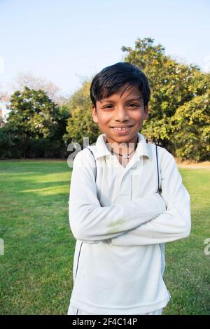 A boy in cricket uniform standing Stock Photo