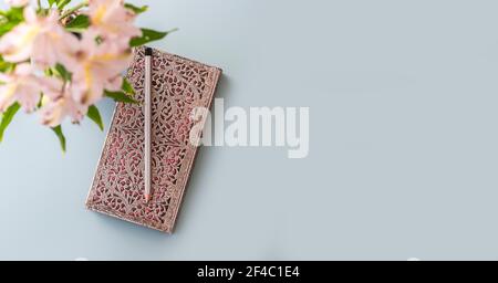 Flat lay of blue working table background with planner, pencil , and plants . Top view, mock up greeting card, craft Notebook and pen.Top view Stock Photo