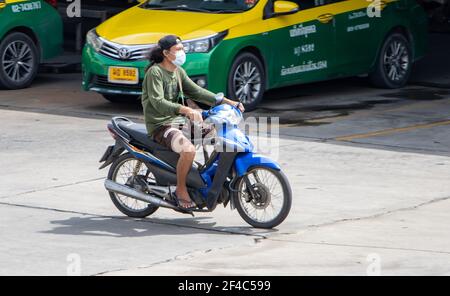 SAMUT PRAKAN, THAILAND, JUNE 26 2020, A man with face mask rides a motorcycle Stock Photo