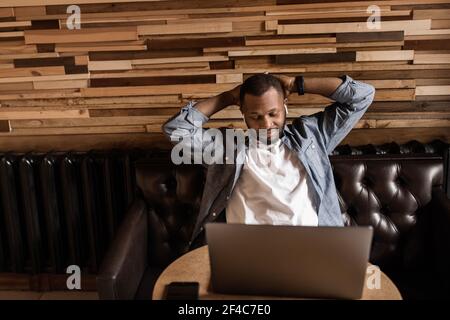 Calm african american businessman relaxing daydreaming at workplace, satisfied young man sitting with his hands up behind his head, leaning back in a Stock Photo
