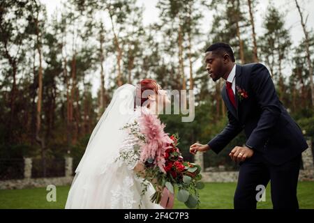 Overjoyed couple dancing, handsome African American man with lovely white woman on wedding day, beautiful bride with charming groom enjoy happy moment Stock Photo
