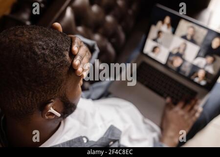 Exhausted tired African American businessman sitting at work desk with closed eyes, falling asleep, overworked young man, unmotivated student sleeping Stock Photo