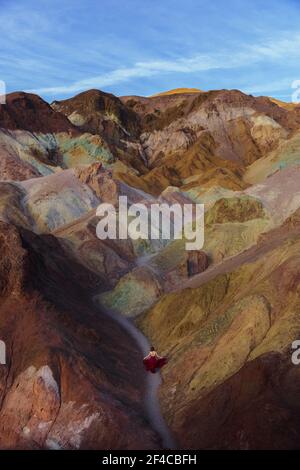 Aerial view of gorgeous woman in red dress floating on calm water by ...