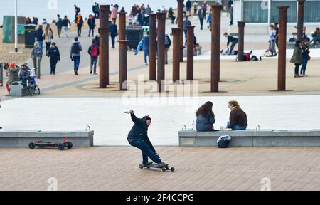 Brighton UK 20th March 2021 - This chap speeds around  Brighton seafront on a warm Spring day along the South Coast :  Credit Simon Dack / Alamy Live News Stock Photo